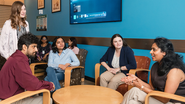 A group of Marvell employees sit in a cafe engaged in a discussion