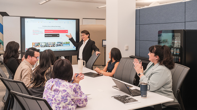 A group of Marvell employees sit in a conference room celebrating the high Great Place to Work score of Marvell.