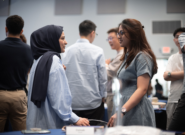 Two Marvell new graduates converse in a room of new grads for the NGAP program