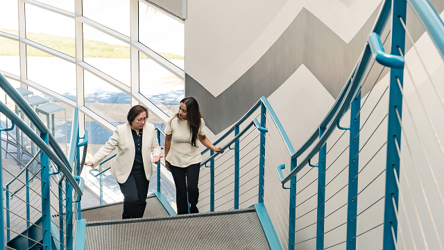 Two Marvell employees walk up a flight of stairs mid-conversation