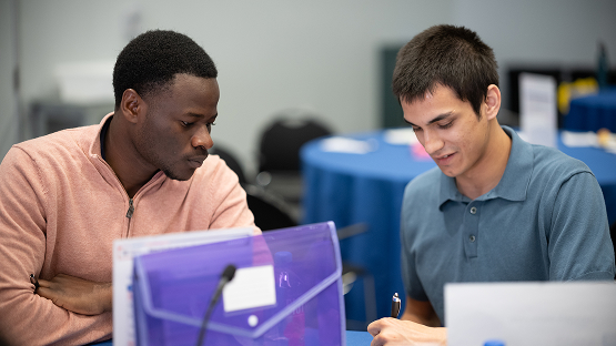 Two new graduates collaborate in a program workshop