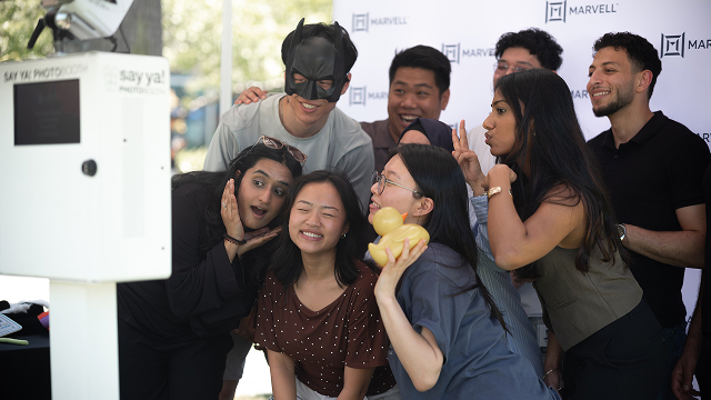 A group of new graduates pose for a photo at a photobooth station